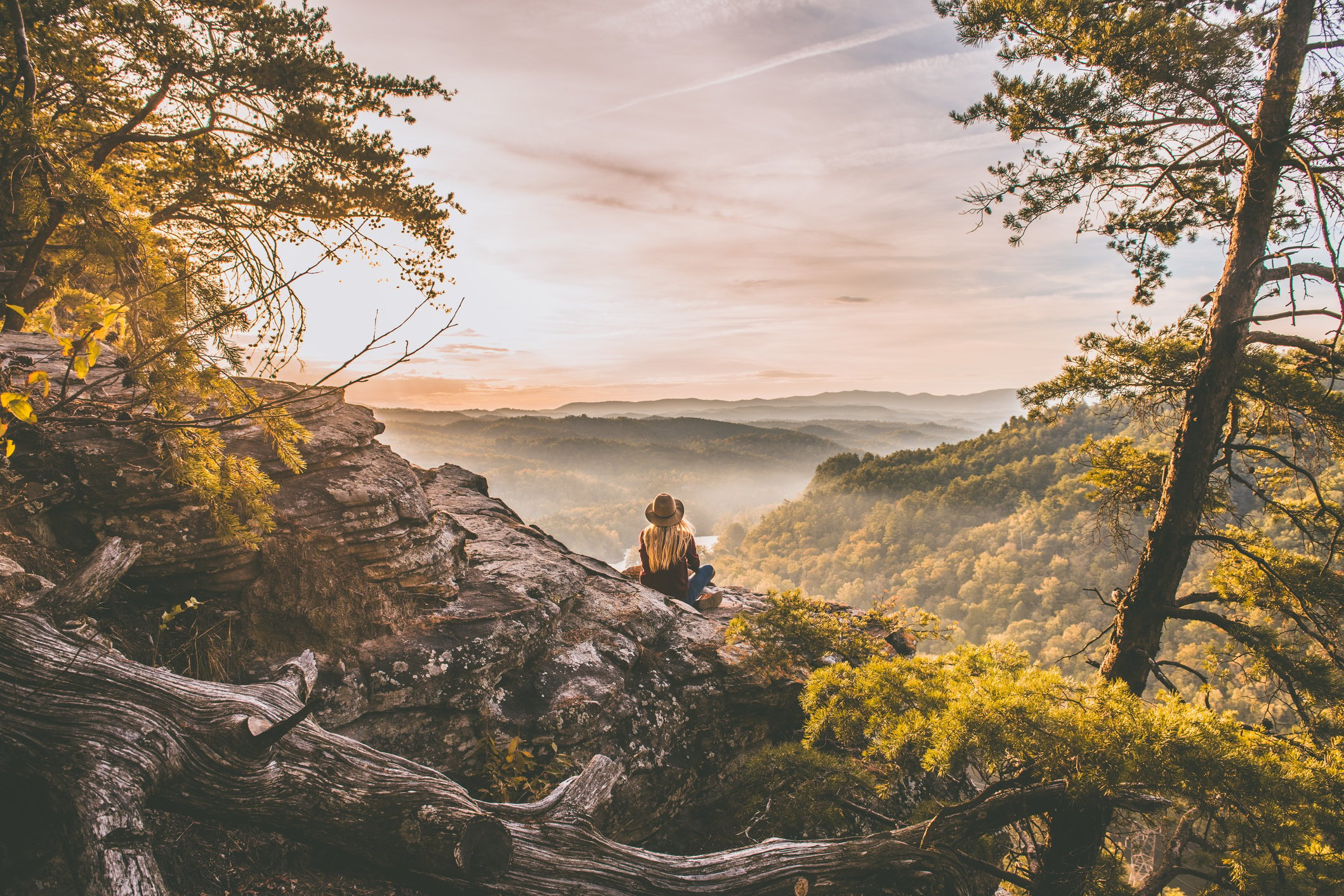 Person Sitting on Top of Cliff